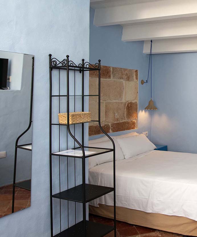 cama doble con mesita de la habitación azul