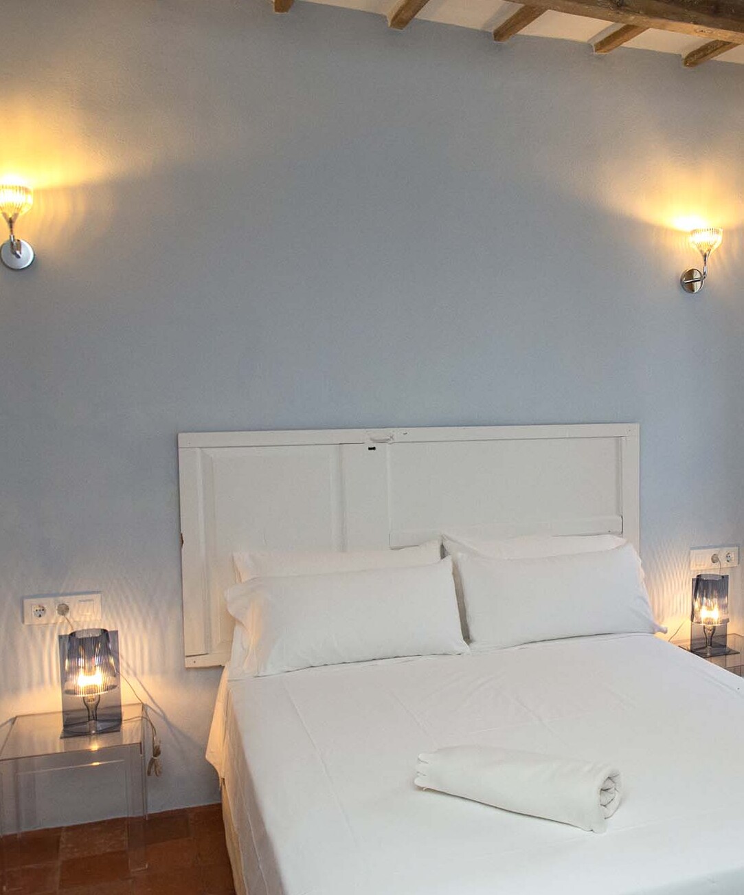 Cama doble de la habitación turquesa con luces encendidas