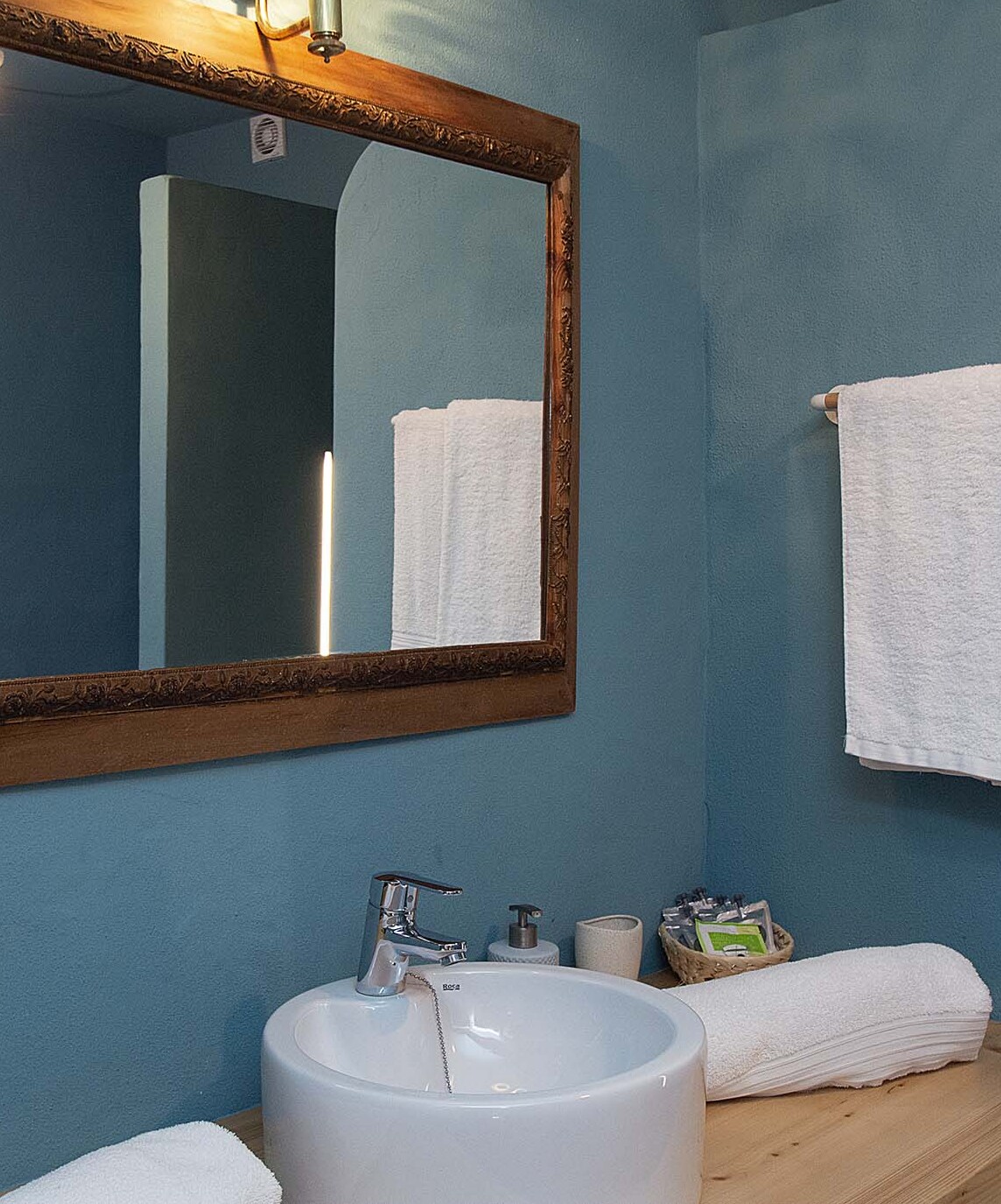 Vista del baño con espejo de la habitación turquesa